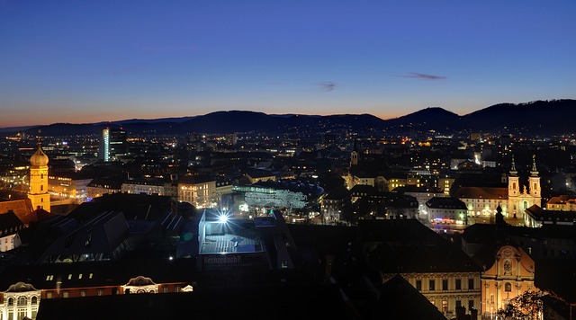 Graz via https://pixabay.com/en/graz-austria-mountains-night-83349/